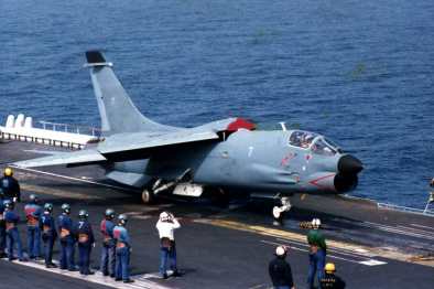 A group of people standing around a fighter jet on a runway Description automatically generated with medium confidence